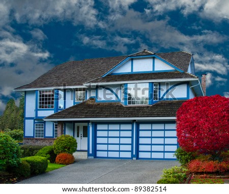 The luxury house with 2 doors garage in a fall time
