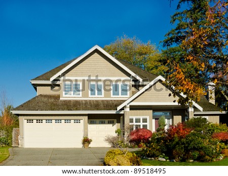Home with covered entry and double three car garage with the dark blue sky in the autumn time of the year. Vancouver.