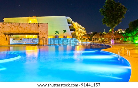 Caribbean resort house at night with a big swimming pool