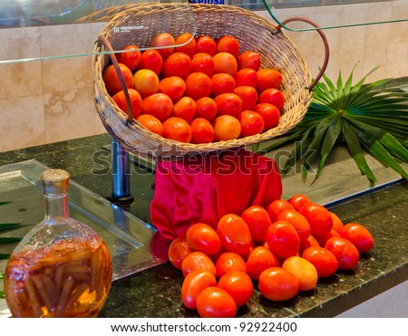 Some tomatoes in the basket on the buffet (restaurant, cafe} counter.