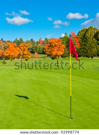 Beautiful golf course with sand bunkers and flag.