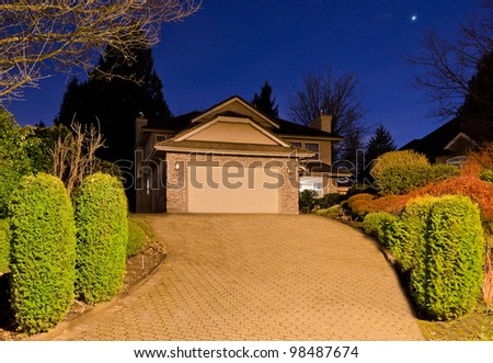 The garage with big driveway  at dusk (night, dawn )  in Vancouver, Canada