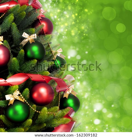 Magically decorated Christmas Tree with balls, ribbons and red garlands on a blurred green shiny, sparkling and fairy background