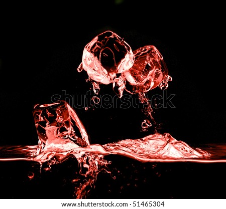 ice cubes dropped into juice with splash on black