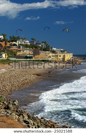 A beautiful vista of County Line Beach in Malibu, with surfers, waves and beautiful houses in the background