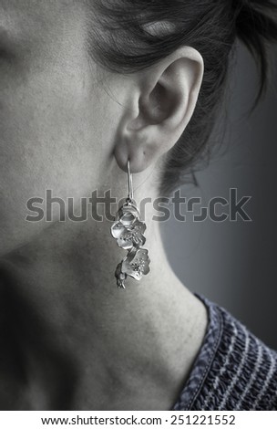 Women ear with silver earring like apple blossom