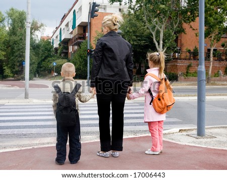 mother is taking children across the street