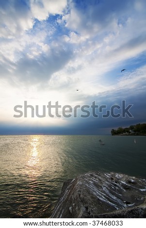 The reflected sun light, dramatic sky and calm waters of Lake Erie make the scene quite remarkable.
