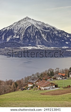 Panoramic lake view of Swiss Niesen mountain near the Thun lake in winter