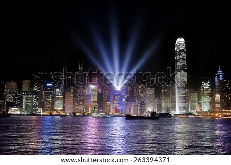 Hong Kong bay and night skyline with cargo ship at symphony of lights show time