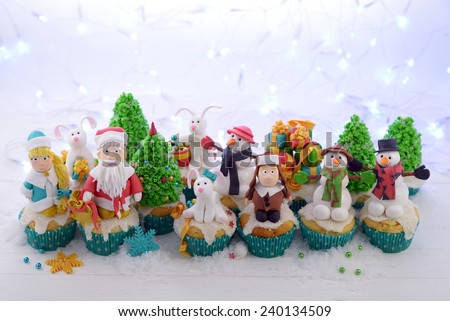 Festive cupcakes decorated with sugar figures of Santa Claus Snow Maiden Christmas tree snowmen rabbits and other.