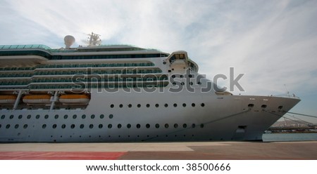 Side detail of a large ocean liner cruise ship with a row of lifeboats in port
