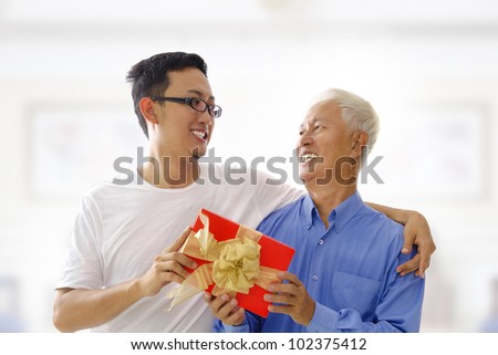 Happy Mixed race Asian father receiving present from his son