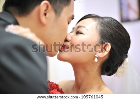 Asian Chinese groom and bride kissing in their wedding day