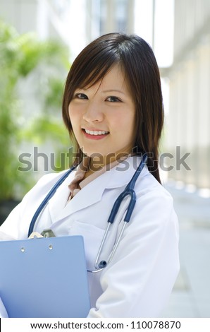 A young Asian Chinese medical student standing in front modern building