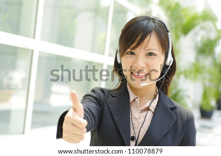 Friendly Customer Representative with headset thumb up during a telephone conversation.