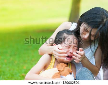 Asian mother is comforting her crying daughter
