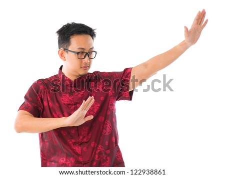 Southeast Asian Chinese man practicing tai chi, isolated on white background