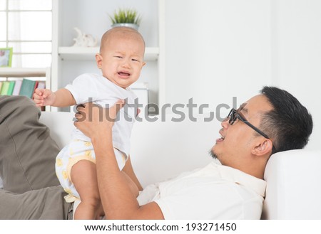 Asian family lifestyle at home. Father comforting crying baby boy.