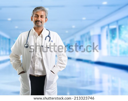 Indian doctor. Mature Indian male medical doctor standing inside hospital. Handsome Indian model portrait.