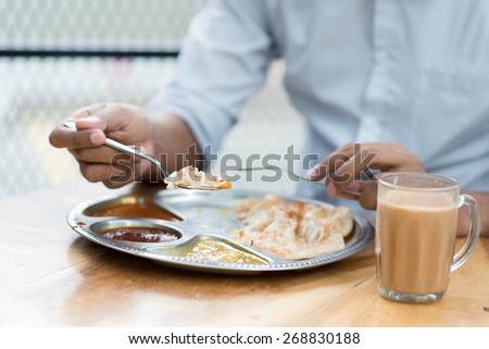 Man having Indian meal at cafeteria.