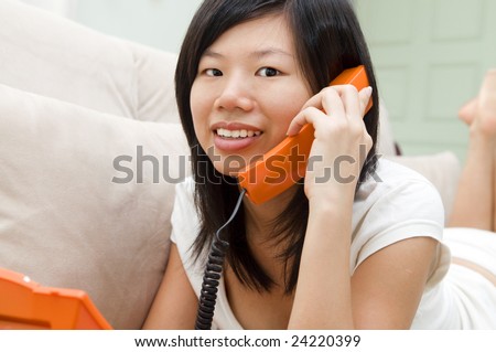 Asian woman on sofa chatting phone