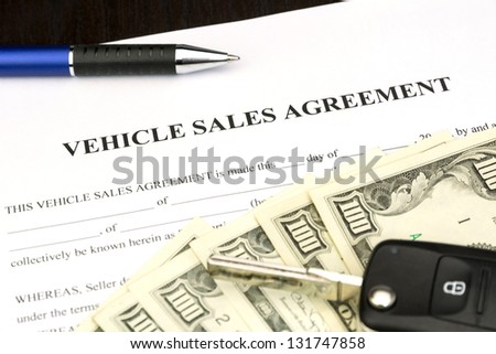 Vehicle sales agreement document contract with car key and pen