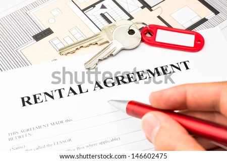 rental agreement contract with red pen and male hand and keys