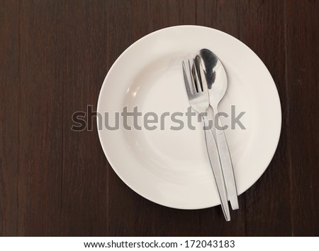 Silverware and plate on wood table