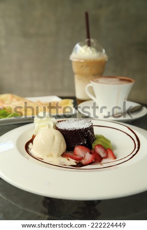 Chocolate Lava Cake with ice cream and beverage in cafe