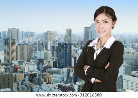 Business woman , crossed arms, with city background