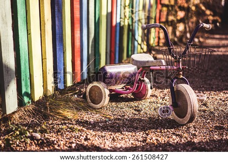 Deserted rusty children\'s tricycle bike, at a playground.