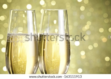 flutes of champagne on golden bokeh background