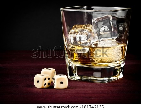 dice near whiskey glass on old wood table, concept of game