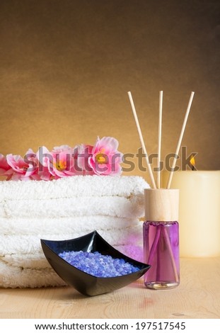Spa massage border background with towel stacked, perfume diffuser and sea salt, warm atmosphere