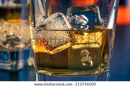 detail of whiskey with ice on bar table lounge bar atmosphere