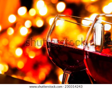 red wine glasses against colorful unfocused lights background, festive and fun concept