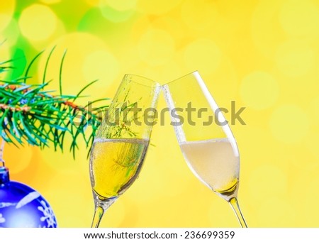 champagne flutes with golden bubbles make cheers on christmas decoration yellow bokeh background, christmas atmosphere