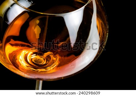 snifter of brandy in elegant glass with space for text on black background
