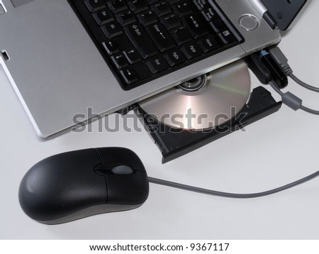 laptop with mouse and dvd tray linking up to network