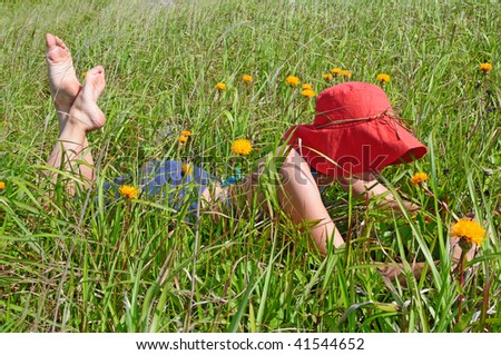 girl resting on the green meadow with flowers