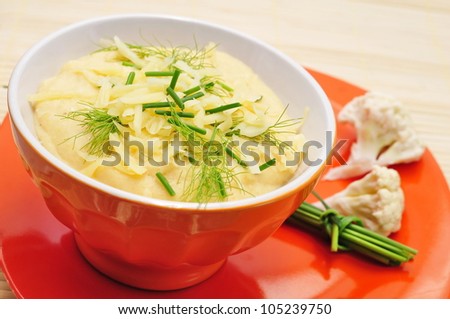 Cauliflower soup in orange bowl