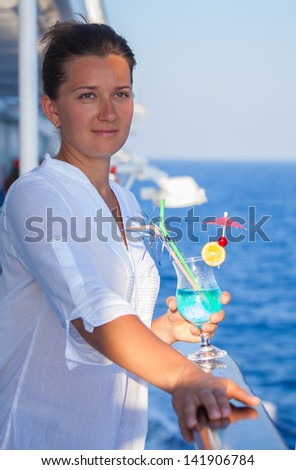 pretty girl with a cold drink, enjoying the outdoors and sea views