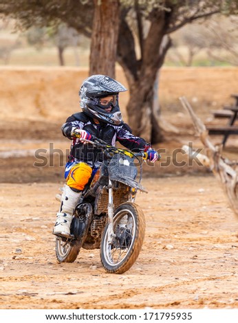 boy riding on motorcycle, dirt