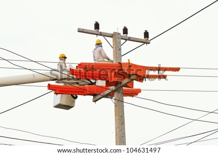 An electrical power utility worker in a bucket fixes the power line.