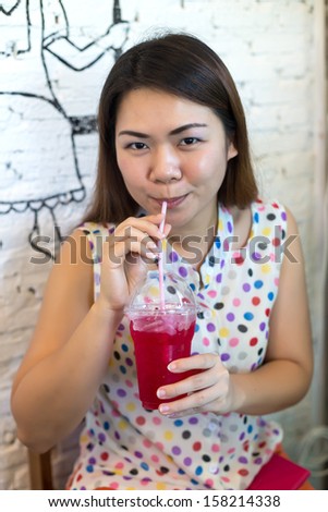 Young woman drinking sweet red soda