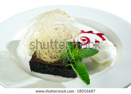 chocolate dessert and ice cream decorated with strands of burned sugar and mint leaves isolated on white