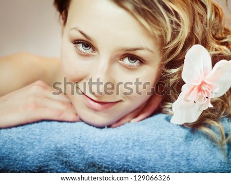 Closeup face of beautiful woman with orchid in hair