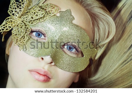 Closeup woman face in yellow carnival sparkling mask