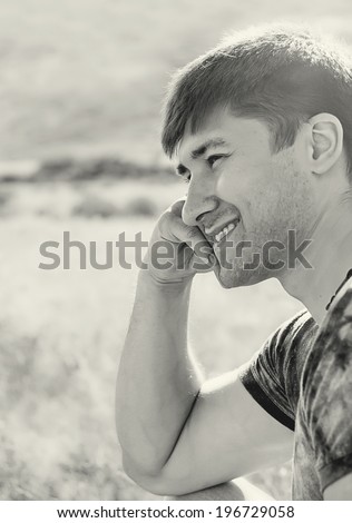 Black and white profile of  handsome laughing man outdoors